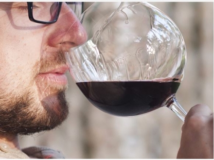 Photo d'un homme sentant l'odeur d'un vin dans un verre